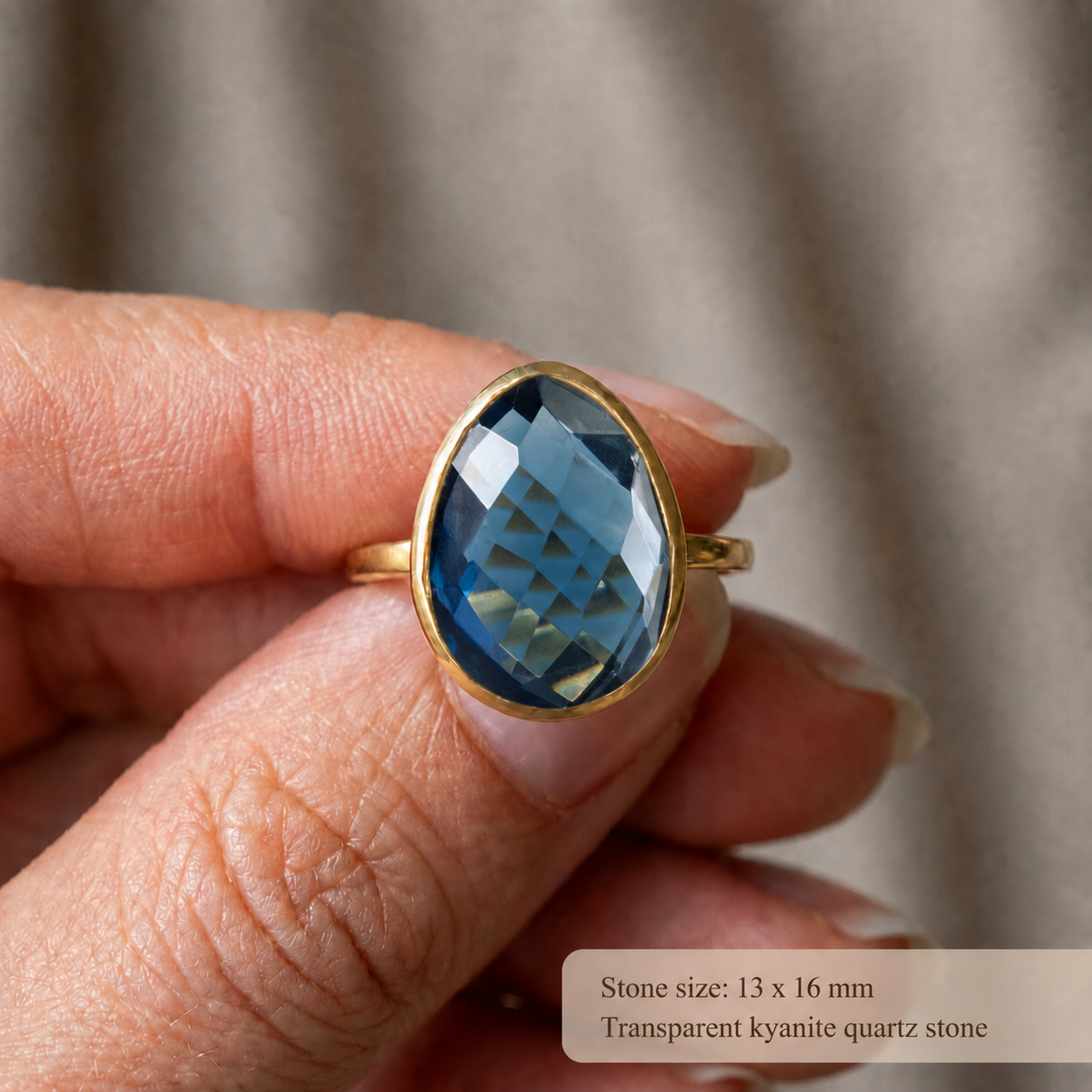 Close-up of large faceted Kyanite gemstone ring showing the 13 x 16 mm deep blue teardrop stone.
