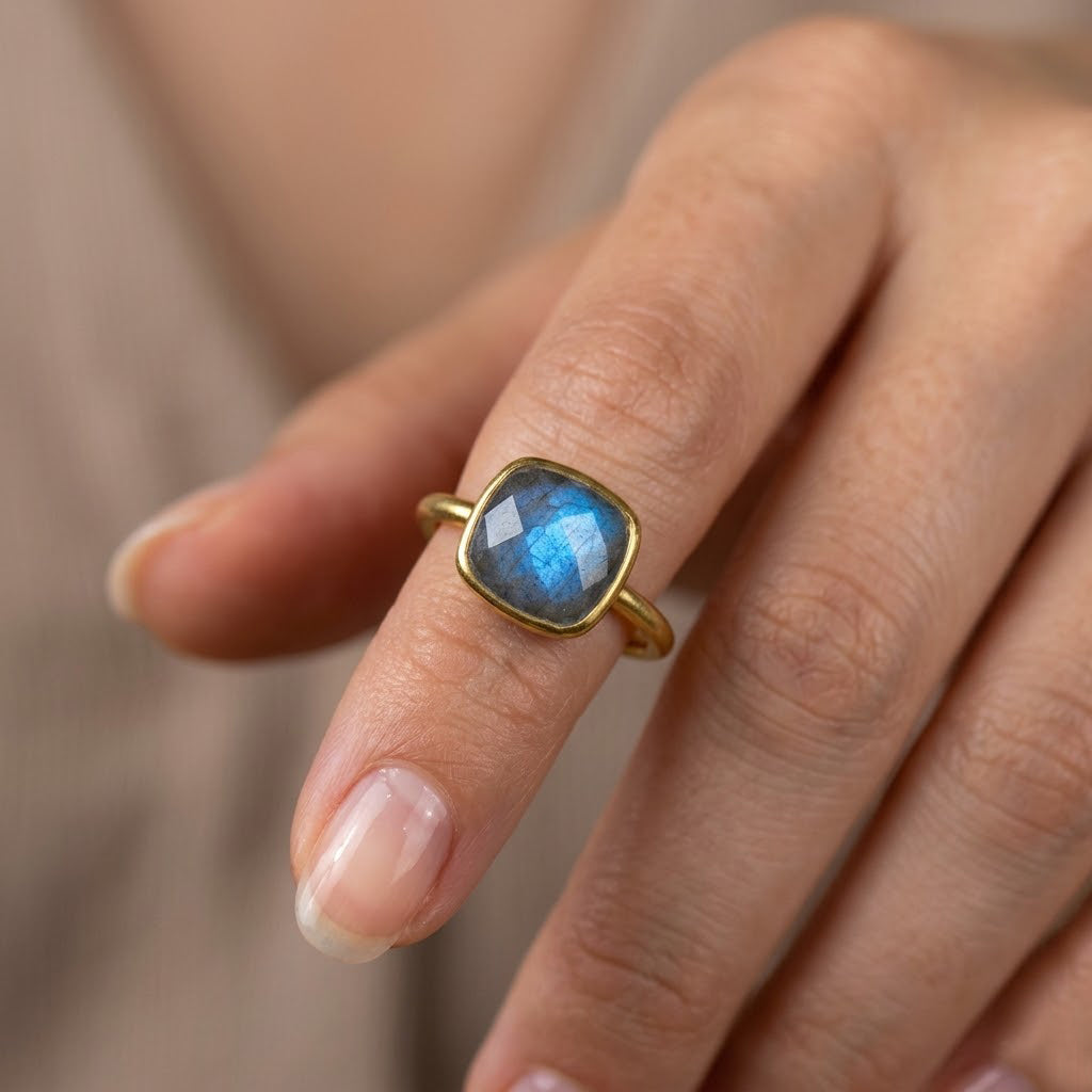 Labradorite statement ring worn on hand with gold band and glowing blue fire stone