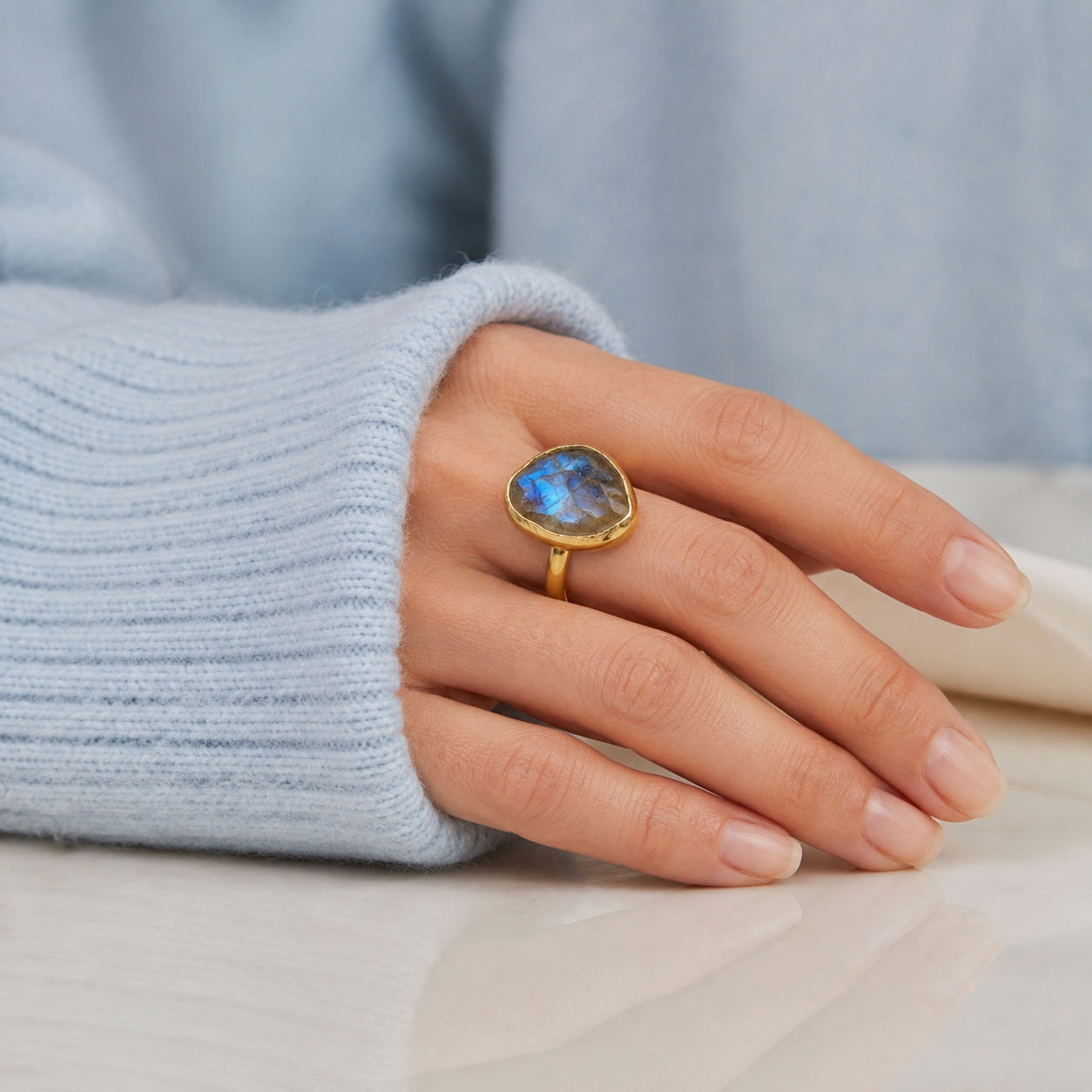 Large blue flash labradorite ring in yellow gold vermeil worn on woman's hand with minimalist band