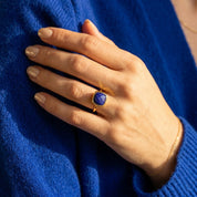 Hand wearing lapis lazuli cushion ring with gold bezel, deep blue gemstone ring for everyday wear or special occasions