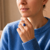 Model wearing deep blue oval lapis lazuli September birthstone ring in gold