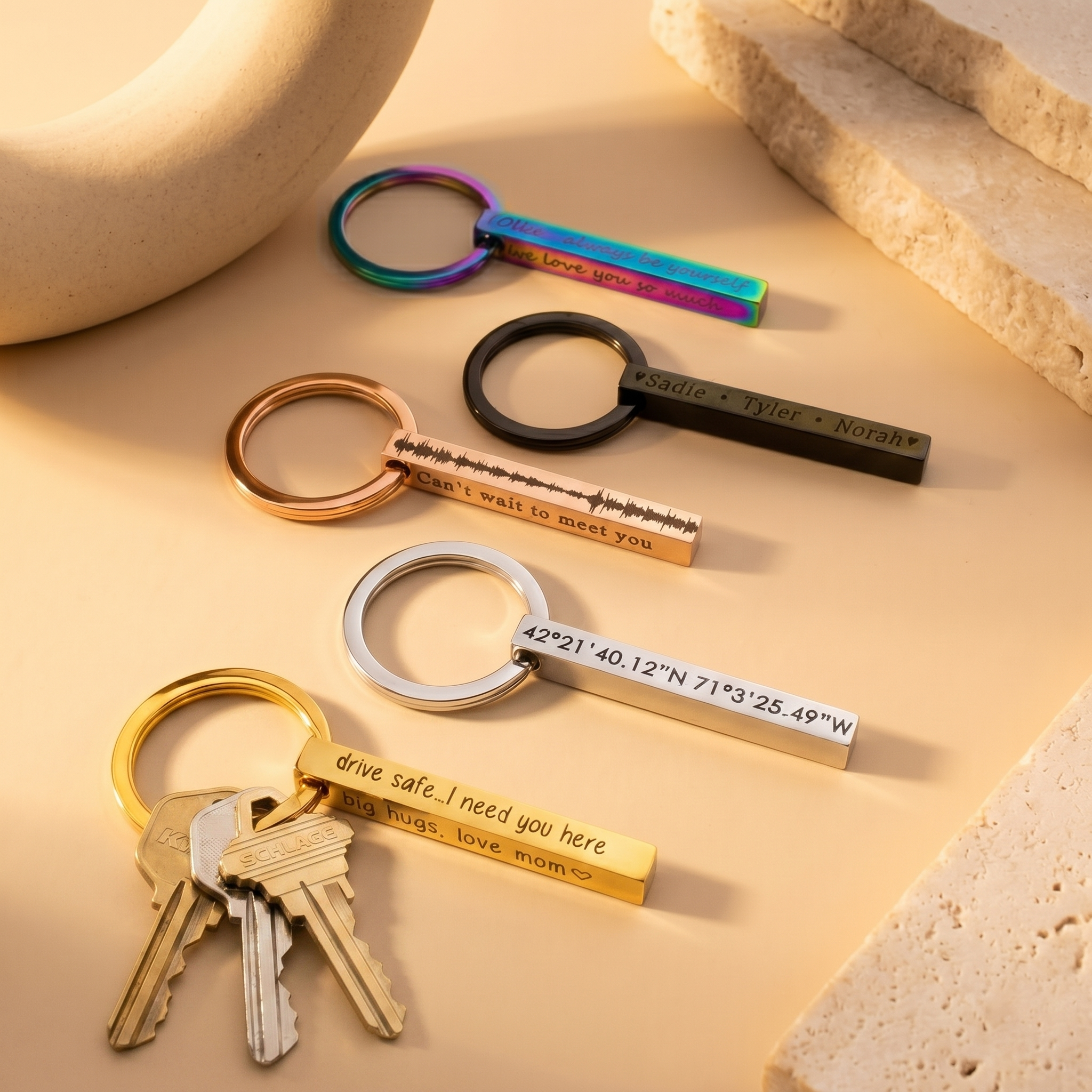 Sleek 3D bar keychains in silver, gold, rose gold, black, and rainbow finishes arranged on a white background, each engraved with custom names, dates, or short messages. Modern personalized keyring set shows scale, polish, and color options—ideal for groomsmen gifts, new-driver “drive safe” presents, and long-distance coordinates keychain ideas for him or her.