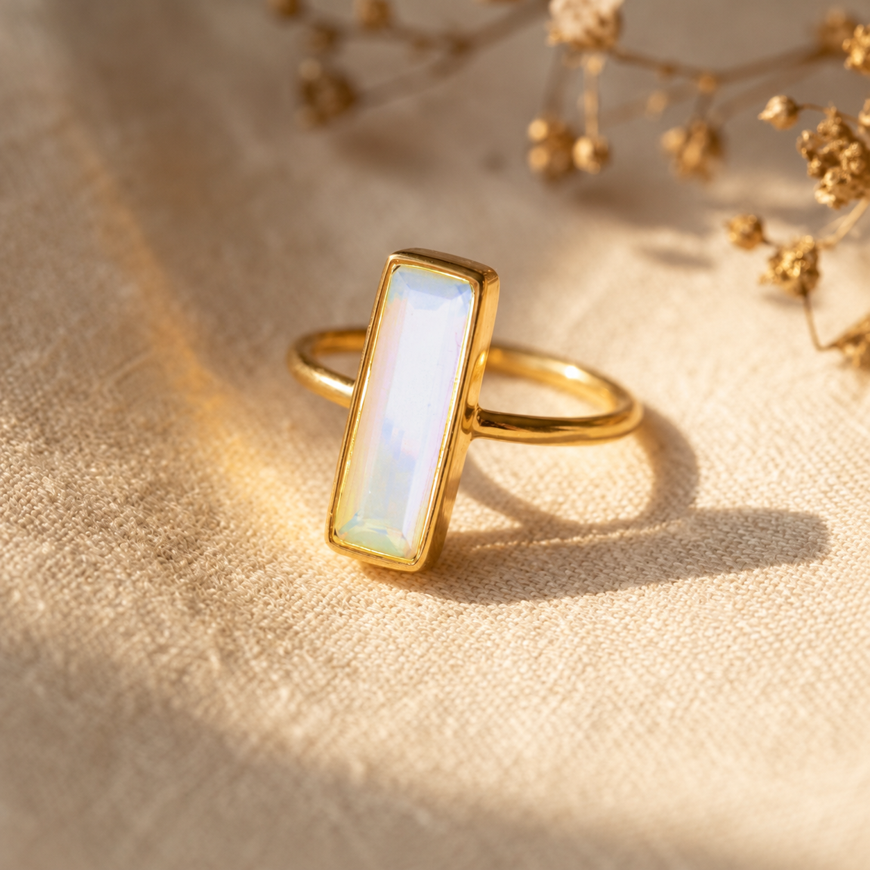 Large Opalite bar ring in yellow gold with iridescent rectangular October birthstone gemstone.
