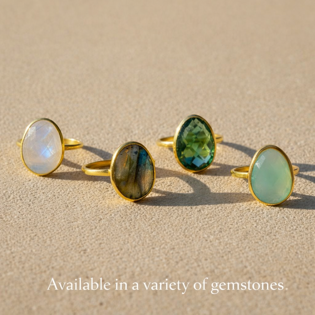 Group photo of oval bezel-set rings displayed in a variety of gemstones, including rainbow moonstone and other colored stones. Minimalist oval gemstone rings designed for stacking and everyday wear, highlighting customization options and gemstone variety. Handmade birthstone jewelry available in multiple stones, perfect for personalized gifting and timeless style.
