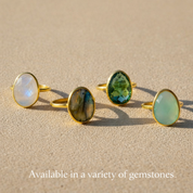 Group photo of oval bezel-set rings displayed in a variety of gemstones, including rainbow moonstone and other colored stones. Minimalist oval gemstone rings designed for stacking and everyday wear, highlighting customization options and gemstone variety. Handmade birthstone jewelry available in multiple stones, perfect for personalized gifting and timeless style.
