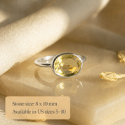 Sterling silver lemon quartz oval ring with text overlay showing 8 x 10mm stone size and available US sizes 5–10.
