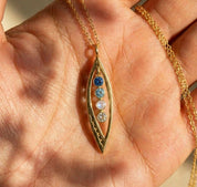 Hand holding custom marquise pendant necklace with multiple birthstones, personalized jewelry gift for mom