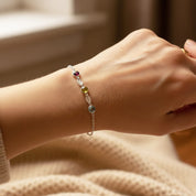 Minimalist wrist photo of custom birthstone and engraved tag bracelet, personalized family jewelry in yellow gold for mom or grandma