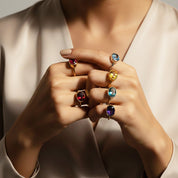 Stacked gemstone rings including blue topaz oval ring, dainty December birthstone jewelry styled for layering