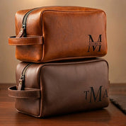 Personalized men’s leather toiletry bags in cinnamon and espresso brown, engraved with monograms and initials, ideal as custom engraved dopp kits for groomsmen, anniversary gifts, or Father’s Day presents. Classic handmade leather design with durable zipper and travel-friendly handle.