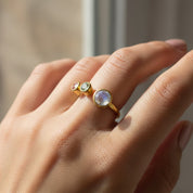Dainty adjustable mom birthstone ring worn on hand, custom family ring with April diamond, May emerald, and June moonstone, elegant minimalist gold jewelry designed to represent children’s birth months in a modern mother’s ring.