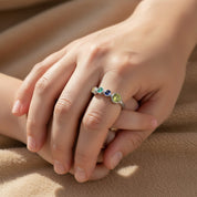Sterling silver custom birthstone ring for mom of three kids shown on a woman’s hand, featuring one larger bezel-set center stone and three smaller child birthstones in a colorful gradient along the slim band. This adjustable family ring is a meaningful piece of personalized jewelry, perfect for everyday wear and as a sentimental Mother’s Day, birthday, or Christmas gift for moms who want to keep their three children close.