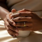 Dainty personalized multi birthstone ring for mom of two kids shown on a woman’s hand while holding a mug, featuring one large 5mm bezel-set mother stone and two small 3mm child birthstones on an adjustable gold open ring. A meaningful mother’s birthstone jewelry gift, perfect for birthdays, Christmas, Mother’s Day, or new mom celebrations, this custom family ring blends comfort, elegance, and sentimental detail in everyday wearable handmade jewelry.