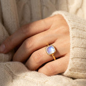 Cushion moonstone ring worn with cozy sweater and minimalist styling