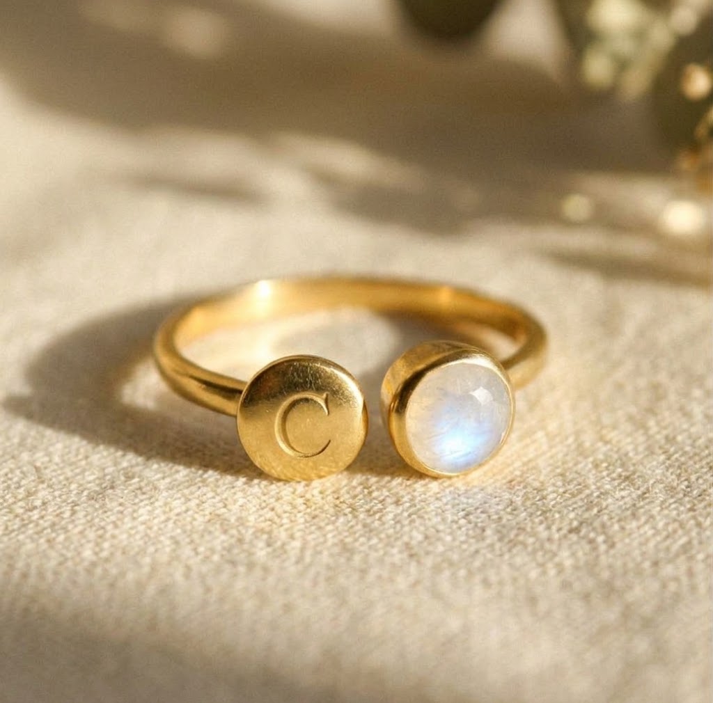 Adjustable rainbow moonstone ring in yellow gold with optional engraved initial disc and 6 mm June birthstone.
