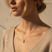 Woman wearing an oval Morganite birthstone bezel necklace styled with a soft neutral outfit, showcasing how the dainty pendant sits on the neckline. Minimalist gold birthstone necklace designed for everyday elegance. Personalized birthstone jewelry gift for women, perfect for Valentine’s Day, anniversaries, or thoughtful birthday gifts.
