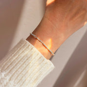A dainty Morse code bracelet on wrist in sterling silver, featuring hidden message beads that spell a secret word. Adjustable and minimalist, this bracelet is a thoughtful gift for girlfriend, boyfriend, or best friend. Perfect for birthdays, Christmas, anniversaries, Valentine’s Day, or everyday wear. Handcrafted in sterling silver, gold filled, or rose gold filled.