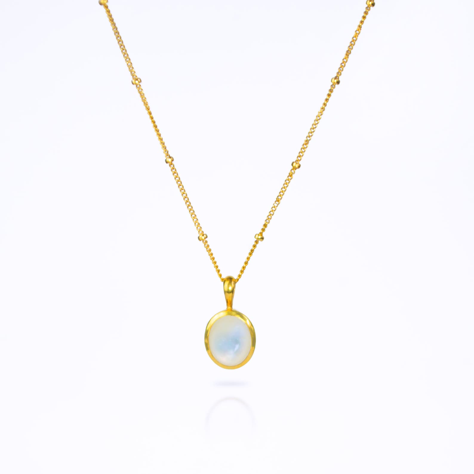 Oval Mother of Pearl Cabochon Bezel Set into a 925 Sterling Silver Pendant Plated in 18k Vermeil Gold sitting on a 14K Gold Filled Satellite Chain against a white background. Iridescent Mother of Pearl Shell Necklace, Gold Dainty Stacking Necklace