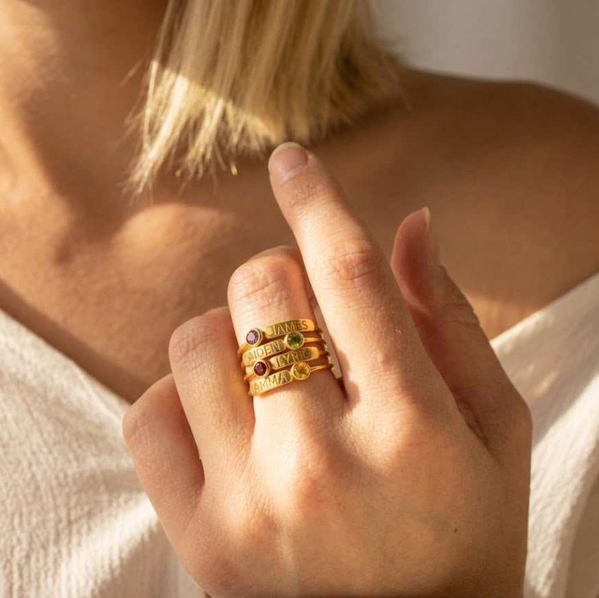 dainty gold stacking birthstone rings worn on hand, personalized engraved rings for everyday jewelry style