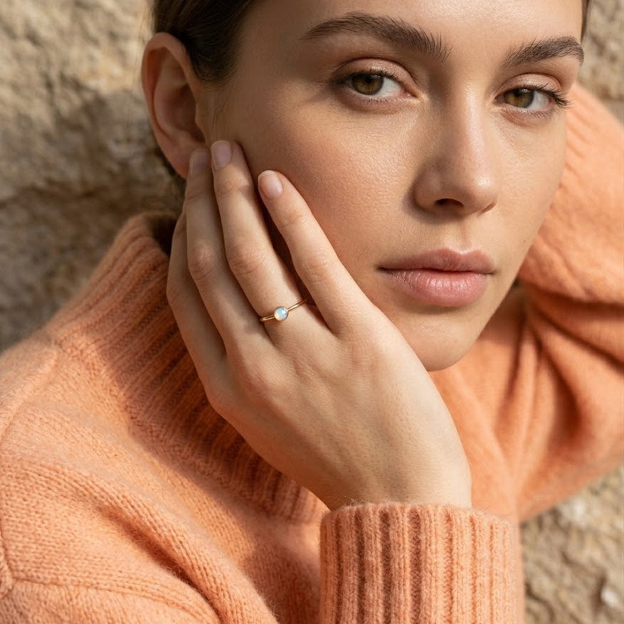 Model wearing opalite ring, minimalist October birthstone ring with glowing white gemstone