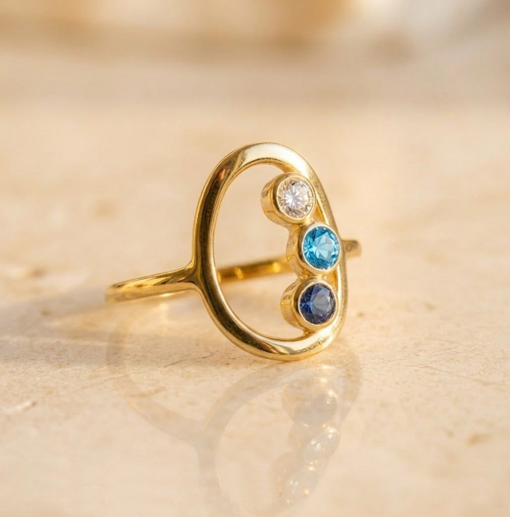 Gold mom birthstone ring with three gemstones representing children
