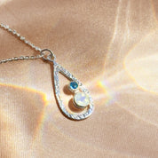 Close-up of custom birthstone necklace for mom in sterling silver with teardrop pendant and colorful stones