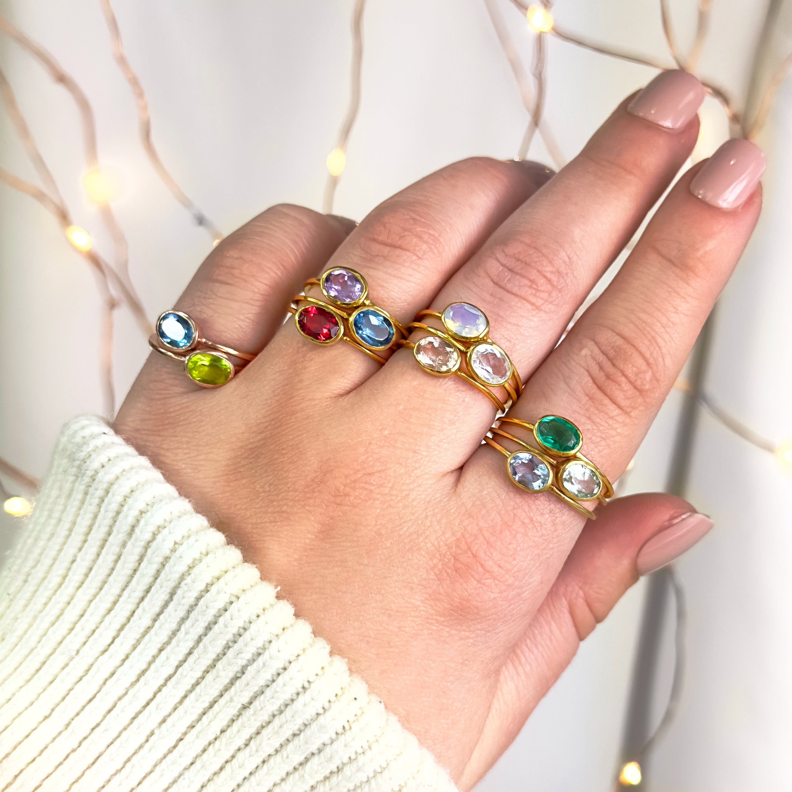 Model stylishly stacking the small oval ring collection. stack set, stacking rings, gemstone ring, birthstone ring, mother's day gift for her, gift for mom, gift for fiance, gift for girlfriend, wedding jewelry, bridesmaid jewelry, anniversary jewelry, anniversary gift, birthday gift, christmas gift, valentine's day gift, valentine's day rings, dainty ring, cocktail ring, statement ring, bezel set, birthstone jewelry, birthstone ring