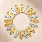 Custom oval name tag charms in gold and sterling silver with engraved names, designed as add-on charms for Danique necklaces and bracelets.