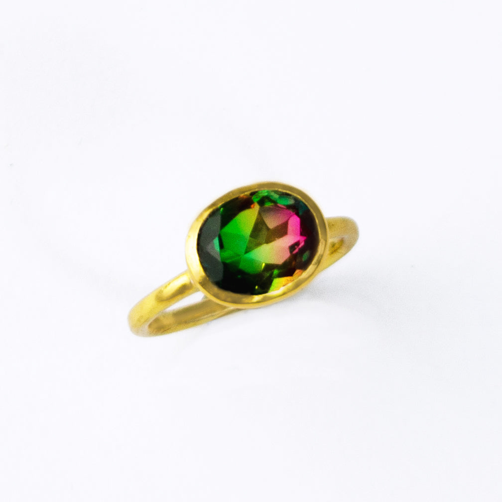 This multicolor watermelon tourmaline quartz ring in vermeil gold. The ring sits against a white background. Tricolor Watermelon Crystal Quartz Oval Ring Plated in 18k vermeil gold on a white background. Three Color Gemstone Ring. Large Oval Ring.