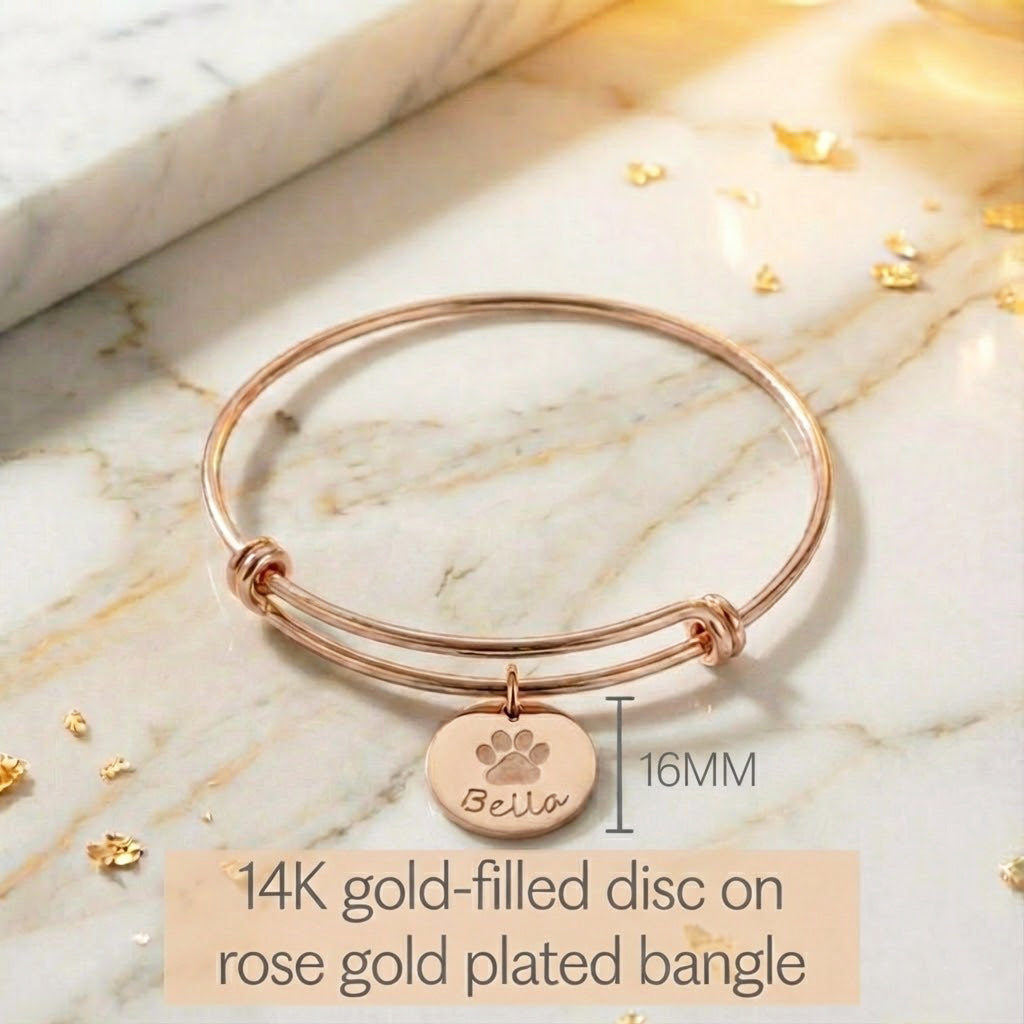 Model wearing stylish rose gold plated paw print disc bangle. Perfect memorial keepsake for any dog mom cat mom. 