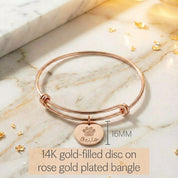 Model wearing stylish rose gold plated paw print disc bangle. Perfect memorial keepsake for any dog mom cat mom. 