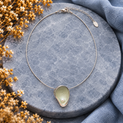 Full Sage Mist pearl teardrop necklace displayed on gray stone background

