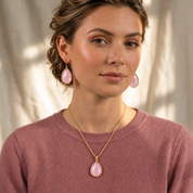 Woman wearing large Pink Chalcedony teardrop earrings with a matching pink gemstone necklace.
