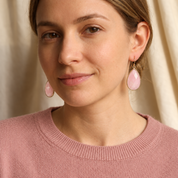 Woman wearing Pink Chalcedony teardrop drop earrings in gold as October birthstone jewelry.
