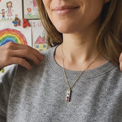 Woman wearing personalized birthstone bar necklace for mom – minimalist vertical family birthstone necklace with colorful gemstones