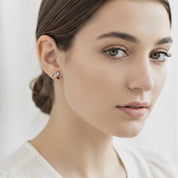 Video showcasing custom birthstone stud earrings on a woman with hair in a low bun, featuring a petite three-stone cluster design in gold with sparkling multicolor gemstones. Dainty personalized family earrings perfect for everyday wear, gifts for mom, grandma or daughter, November birthday, Mother’s Day or Christmas, handmade Danique Jewelry minimalist style, customizable and hypoallergenic.