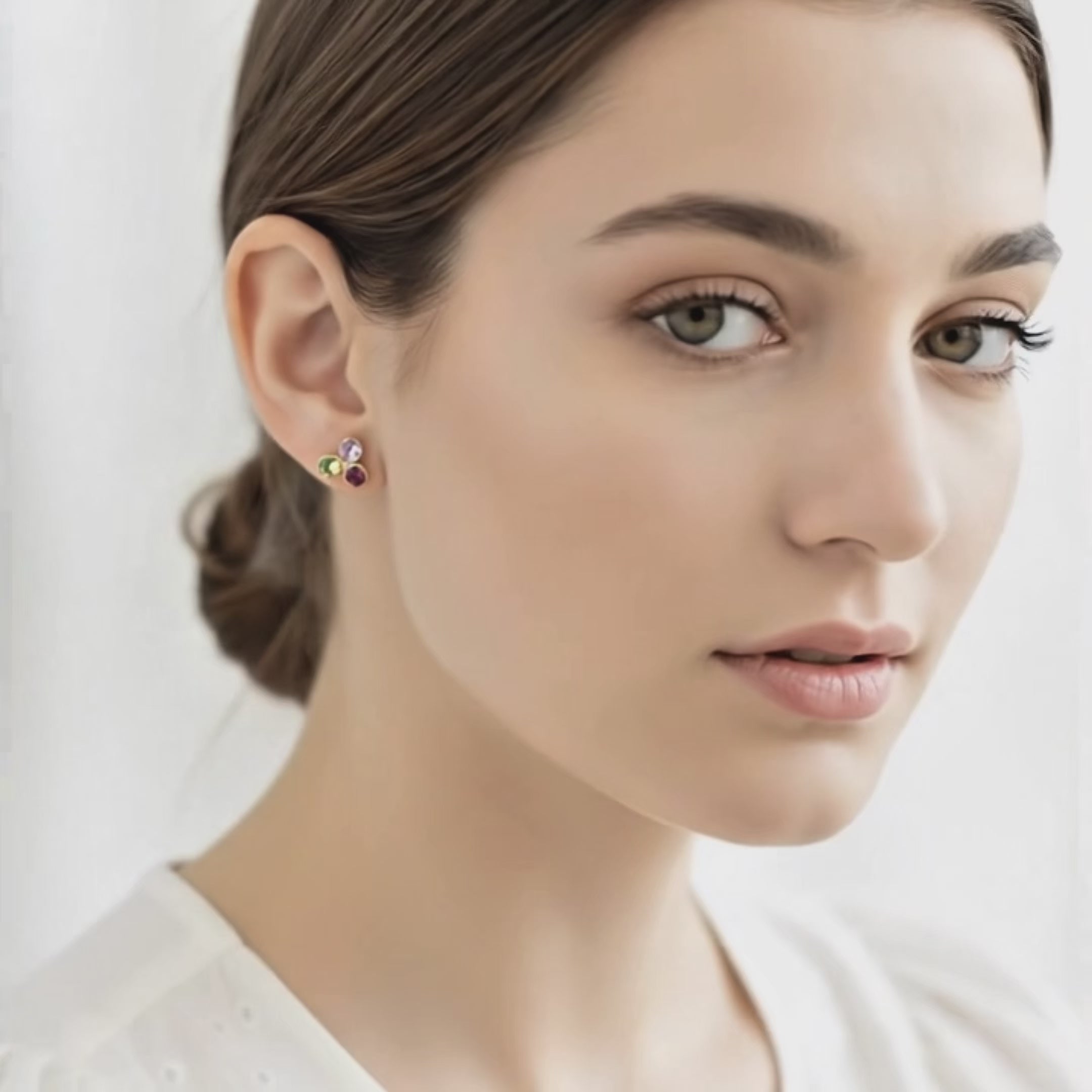 Video showcasing custom birthstone stud earrings on a woman with hair in a low bun, featuring a petite three-stone cluster design in gold with sparkling multicolor gemstones. Dainty personalized family earrings perfect for everyday wear, gifts for mom, grandma or daughter, November birthday, Mother’s Day or Christmas, handmade Danique Jewelry minimalist style, customizable and hypoallergenic.