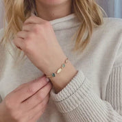 Video of model is wearing our gold filled 6mm birthstone bracelet with kyanite and aqua chalcedony stones and two marquis engraved name tags. 