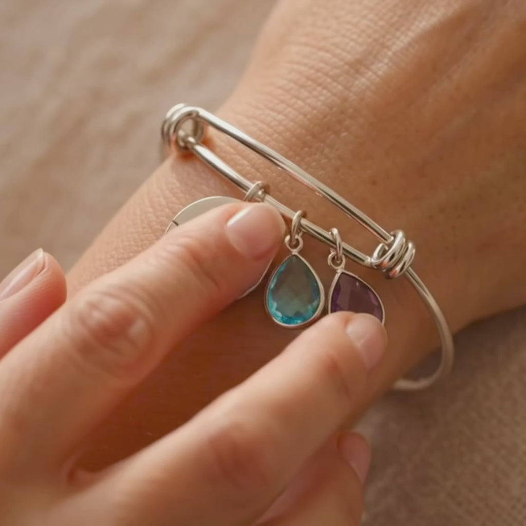 Video showcasing a  personalized birthstone bangle bracelet with engraved mama disc charm and custom birthstone in gold, rose gold or sterling silver