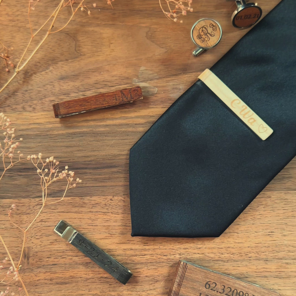 A pan over shows a variety of custom engraved rustic wooden tie clips and cuff links. A birch tie bar is turned front to back to show engravings on both sides. engraving options are monograms, photographs, names, initials, messages, and dates.  Matching cufflinks available. 6 wood finishes to choose from. Perfect for outdoor weddings.