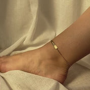 Video of model showcasing the pet paw print bar anklet which is gold filled