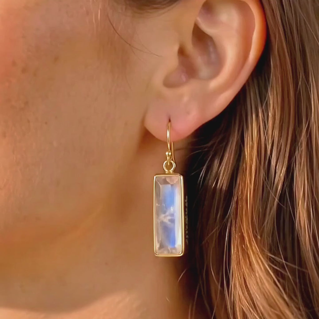 video showcasing delicate baguette cut birthstone earrings in gold vermeil, featuring an elongated rectangular gemstone that catches the light beautifully, shown worn for scale and movement; available in all birthstones for personalized gifting, including January garnet, February amethyst, March aquamarine, May emerald, July ruby, September sapphire, November citrine, and more; elegant minimalist design perfect for everyday wear, birthdays, anniversaries, and holiday gifts
