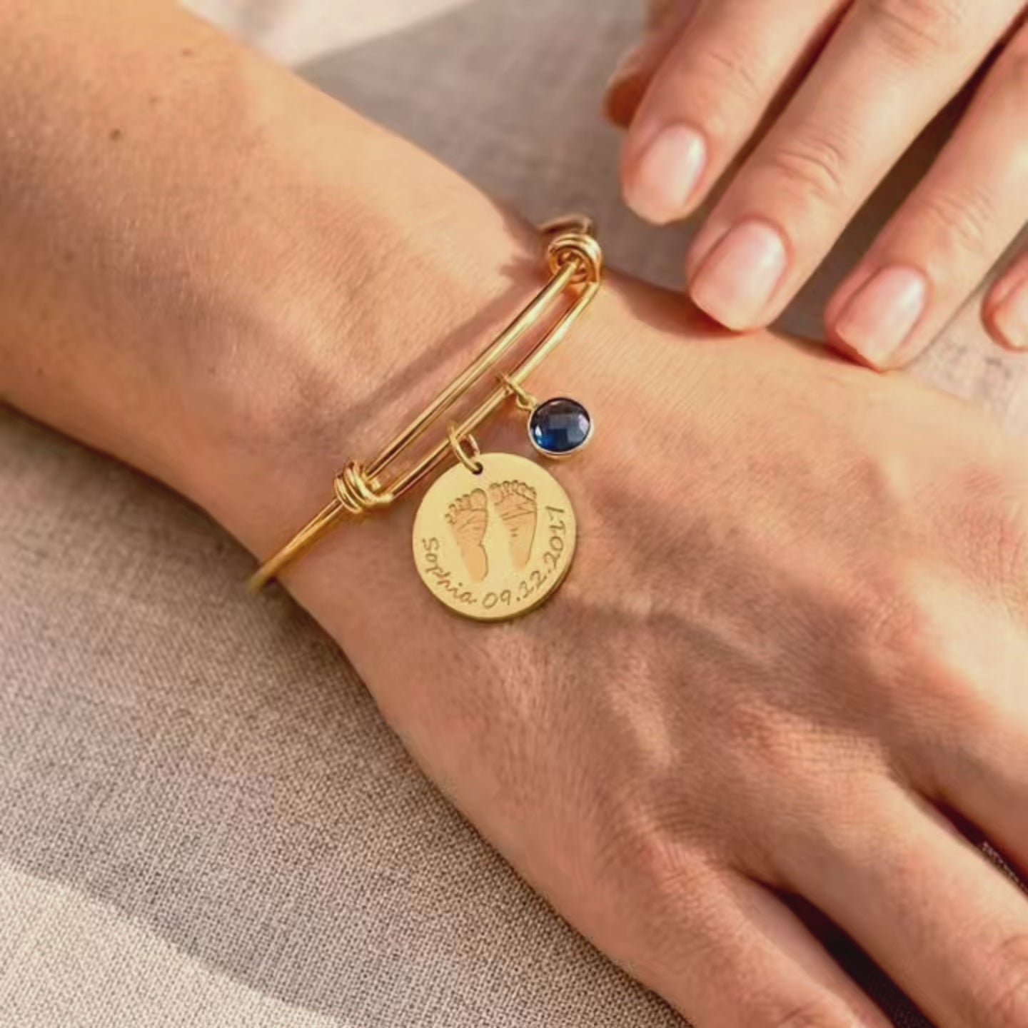 A video showcasing Personalized baby footprint birthstone bangle bracelet with engraved name and date, a meaningful new mom keepsake bracelet in gold.