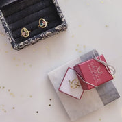 A shot of multiple birthstone rings in a ring tray and an open danique jewelry box. A person tries one on.This delicate egg shaped piece can be set with your choice of birthstone, with gemstone options for every month, plus alternative options if you want something a little different. Rings are available in gold, rose gold, or sterling silver and are hand crafted to your unique style. Birthstones available for January, February, March, April, May, June, July, August, September, October, November, December. 