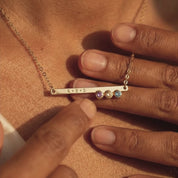 A video showcasing aDainty gold birthstone bar necklace with engraved name and tiny birthstone charms.