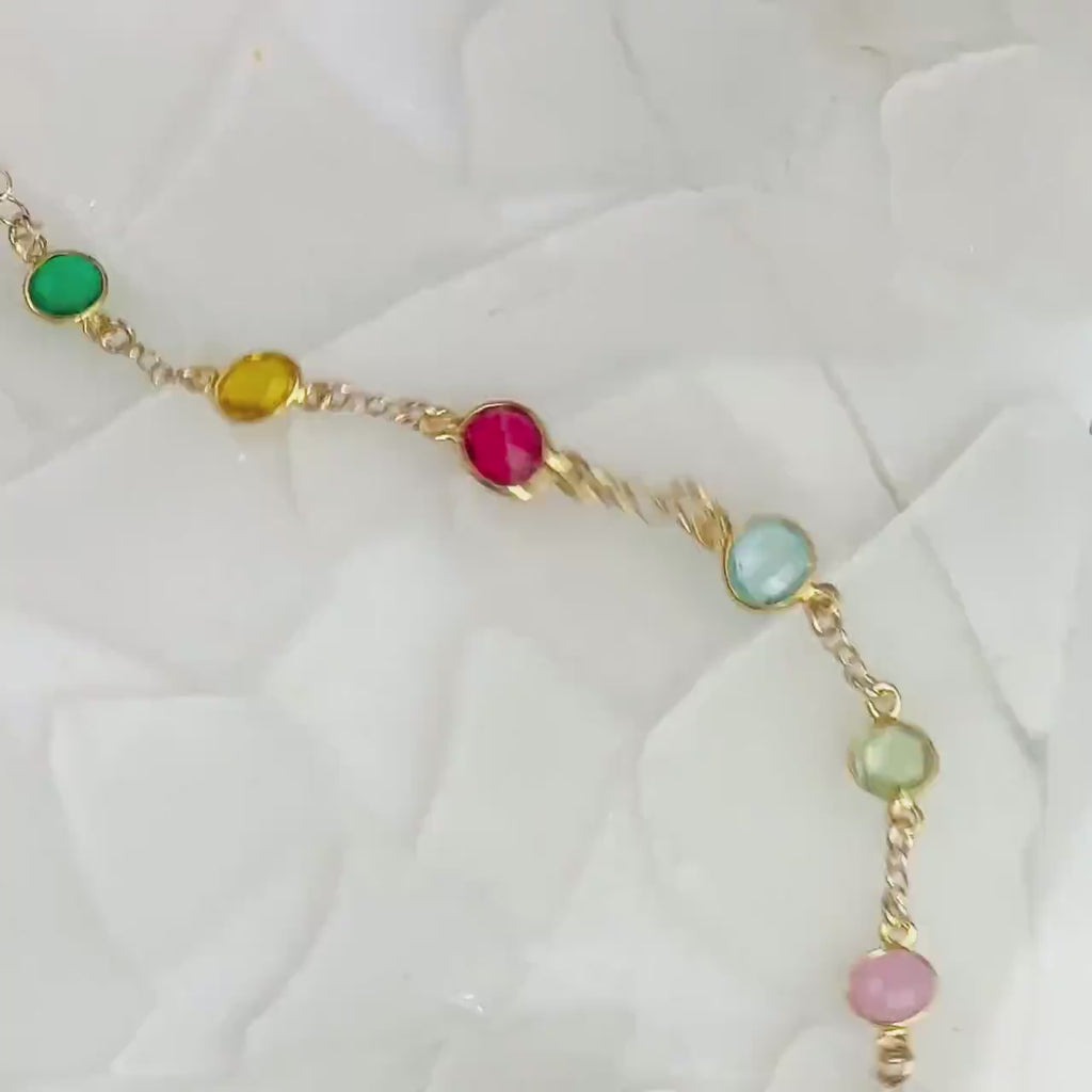 Video of Gold filled station bracelet friendship bracelet taylor swift inspired music lover. Side view with eight gemstones including kyanite, garnet, pink chalcedony, peridot, blue topaz, ruby, citrine and green onyx. Birthstone bracelet, birthstone jewelry