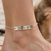 A video showing a personalized pet bar anklet with a pet's name and paw print available in solid sterling silver, 14k gold filled, or 14k rose gold filled.