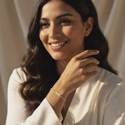 Smiling woman wearing a dainty gold bar bracelet, showcasing a personalized engraved bracelet with a slim rectangular plate on a delicate chain, minimalist everyday jewelry in 14k gold filled, perfect custom gift for her, best friend, sister, bridesmaid or birthday video showcase.
