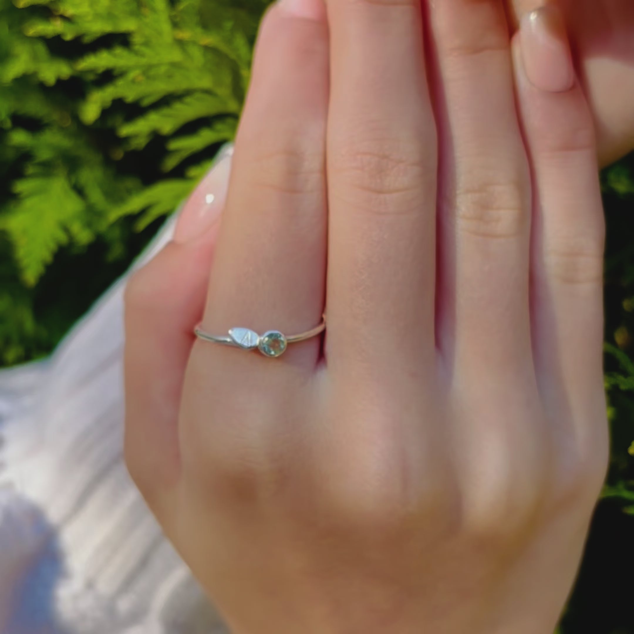 A person wears a silver leaf engraved initial ring with green amethyst birthstone. A hand shows off a close shot of the same ring. A person with coral nail polish wears a silver engraved leaf ring. Two hands against a tree, one of them wears an engraved stackable leaf ring. Custom stacking ring set, mother's ring set, mom jewelry, mother daughter matching rings, sterling silver or 18k gold or rose gold vermeil, customizable birthstones and engraved initial letters on dainty leaf charm ring