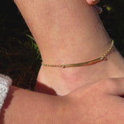 A person wears a gold morse code anklet. The camera pans over two anklets on their side, one in silver and one in gold. Each is engraved with a secret message.  A person shows the engraved bar up close. A silver bar anklet in an open red Danique Jewelry box. Christmas gift for girlfriend, best friend secret message gift, personalized layering anklet durable sturdy daily wear everyday wear anklet for women